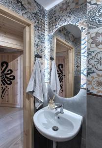 un bagno con lavandino e specchio di Wygodno a Szlembark Altre 115 foto