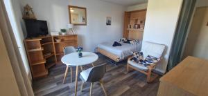a small room with a bed and a table and chairs at Studio à 10min à pieds des Cures in Gréoux-les-Bains