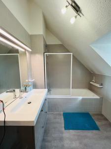 a bathroom with a sink and a bath tub at L'esprit vacances-T3 à Port La Forêt in La Forêt-Fouesnant