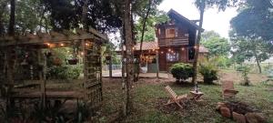 een klein huis met een tafel en stoelen in de tuin bij Birds' Corner Cabin in Curitiba