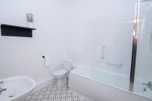 a white bathroom with a toilet and a sink at Amber Serviced Rooms - Free parking Self Check-In with access to shared kitchen in Hull +18 photos
