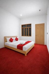a bedroom with a large bed with a red carpet at Amrit Niwas in Prayagraj
