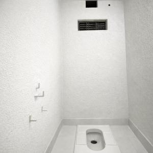 a white bathroom with a toilet in the corner at Amrit Niwas in Prayagraj