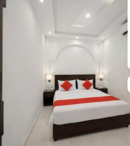 a bedroom with a large bed with red pillows at Amrit Niwas in Prayagraj