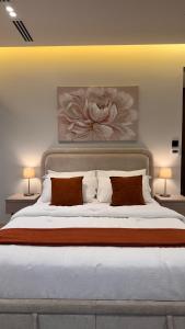 a bedroom with a large bed with a flower painting on the wall at Hanay Studio in Al Khobar