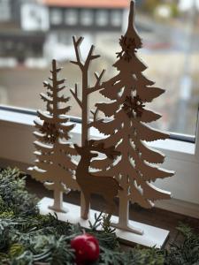 a wooden christmas ornament of trees and a deer at Unser Märchenhaus in Braunlage