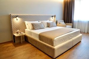 a bedroom with a large bed and a chair at Hortus Hotel Tirana in Tirana