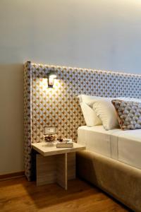 a bedroom with a bed with a table next to it at Hortus Hotel Tirana in Tirana