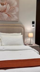 a bedroom with a bed with a flower painting on the wall at Hanay Studio in Al Khobar +7 photos