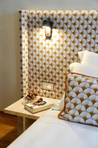 a bedroom with a bed with a table next to it at Hortus Hotel Tirana in Tirana