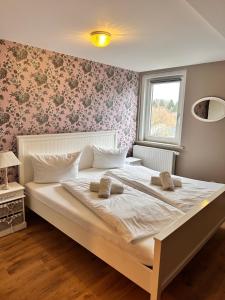 a bedroom with a large bed with pink floral wallpaper at Unser Märchenhaus in Braunlage