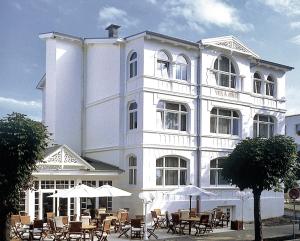 a white building with tables and chairs in front of it at freustil Boutique Hotel in Binz