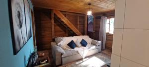 een woonkamer met een witte bank en blauwe kussens bij Birds' Corner Cabin in Curitiba