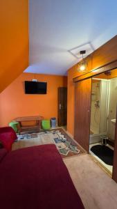 een woonkamer met een rode bank en een tv bij Pokoje Ewka in Czarna Góra