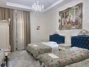 a hotel room with two beds and a chandelier at innstation guesthouse in Rome +31 photos