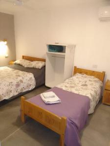 una camera con due letti e un tavolo con asciugamani di Kusylla Wasy refugio de montaña a Amaicha del Valle