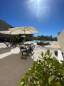 een tafel en stoelen met een parasol op een strand bij Loft 11, caminho do mirante in Iguaba Grande +4 foto's