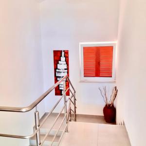 a staircase in a white room with a window at Apartmani Attila in Trogir