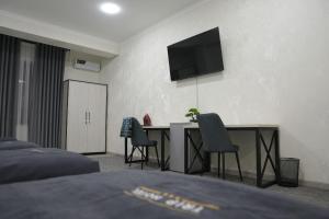 a bedroom with a desk with two chairs and a television at TRIP Hotel in Toshkent-Passajir Bekati