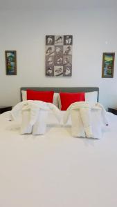 a white bed with white sheets and red pillows at Beautiful Bungalow 5, Koh Chang in Ban Dan Mai