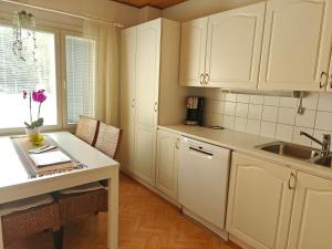 - une cuisine avec des placards blancs, un évier et une table dans l'établissement Peaceful house for relaxing, à Oulu 42 autres photos