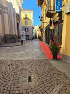 a cobblestone street in a city with a red sidewalk at Julias house in Biella