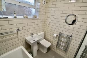 a white bathroom with a toilet and a sink at Driftwood Heart in Freshwater +64 photos