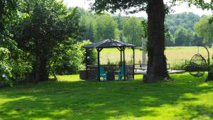 een prieel midden in een tuin met een boom bij La Vache Bleue in Saint-Pierre-de-Fursac