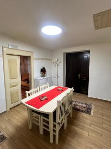 a dining room with a white table and chairs at Vila Korchari Dardhe in Korçë
