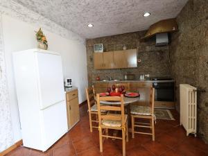 una cucina con frigorifero bianco, tavolo e sedie di Refúgio da Natureza a Monte Córdova Altre 6 foto