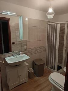 ein Badezimmer mit Waschbecken, Toilette und Spiegel in der Unterkunft La Casa del Borgo-intero appartamento in Latina