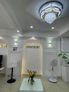 a room with a chandelier and flowers on a table at LAKSHMI Apartment & Hotel Da Nang in Danang