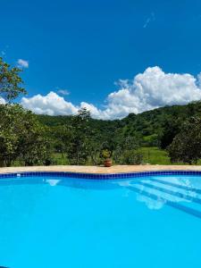 una grande piscina con una montagna sullo sfondo di Casa Das Flores Piri a Pirenópolis