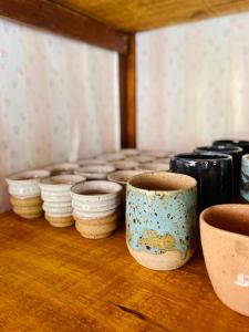un gruppo di ciotole che siedono sopra un tavolo di Casa Das Flores Piri a Pirenópolis