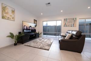 a living room with a couch and a flat screen tv at Henley Brook - Finest in Henley Brook