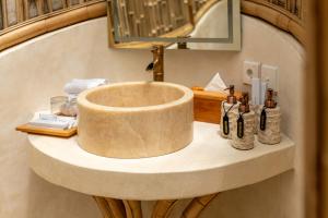 een stenen wastafel in een badkamer met flessen erop bij Umawana Villas in Tegalalang +59 foto's