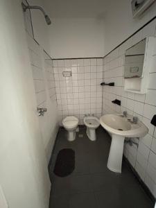 een witte badkamer met een wastafel en een toilet bij Hotel gade in Mar del Plata