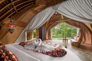 een slaapkamer met een bed met een zwaan erop bij Umawana Villas in Tegalalang