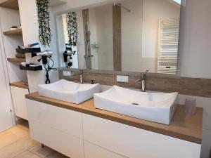 a bathroom with two white sinks and a mirror at Ferienwohnung Moser in Pinsdorf +67 photos
