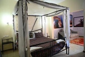 a bedroom with a bed with a canopy at Hotel le Mbosse in Niaga