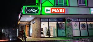 eine Ladenfront mit vielen Schildern bei Nacht in der Unterkunft Apartman Standard Lux u Kraljevim Čardacima in Kopaonik