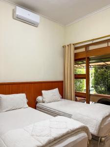 En eller flere senge i et værelse på Kartika Syariah Guest House