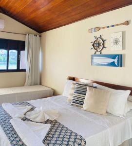 ein Schlafzimmer mit einem großen Bett und einer Holzdecke in der Unterkunft Pousada Recanto da Pedra in Iriri