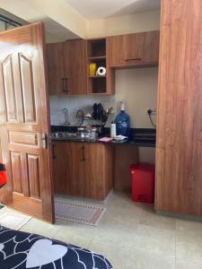 a kitchen with wooden cabinets and a open door at Rees haven in Nanyuki