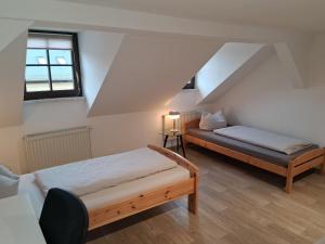 une chambre avec deux lits dans un grenier dans l'établissement L118 Vermietungen, à Zwickau