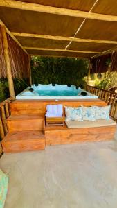 a wooden boat with a tub in the middle at Eliza, Bangalô vista mar em Trancoso in Trancoso