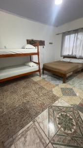 Camera con 2 letti a castello e pavimento piastrellato. di Quartos Beira Mar ARROIO TEIXEIRA a Capão da Canoa