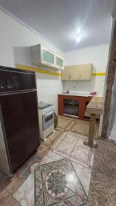 una cucina con frigorifero nero in camera di Quartos Beira Mar ARROIO TEIXEIRA a Capão da Canoa