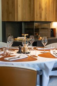 a table with wine glasses and napkins on it at LaCorniche Hôtel in Contrexéville