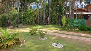 a garden with two birds in the grass at Sopro da Serra Chalé Papagaio in Gonçalves